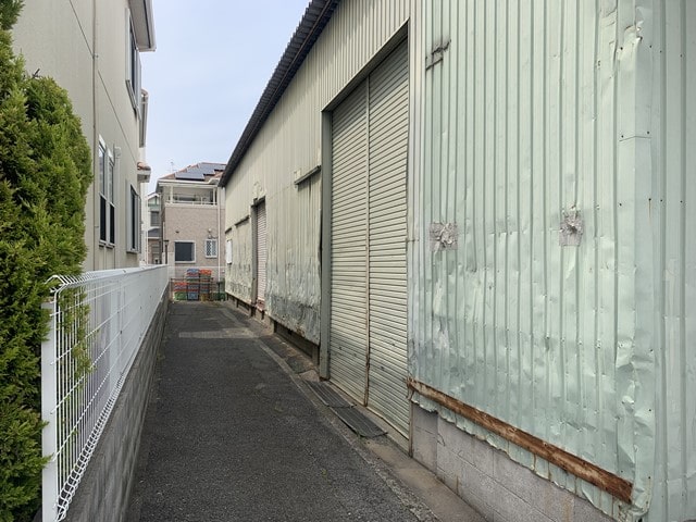 建物横側に通路とシャッターがあります。