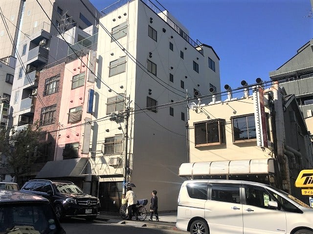 中央の白い5階建の建物が対象物件となります。